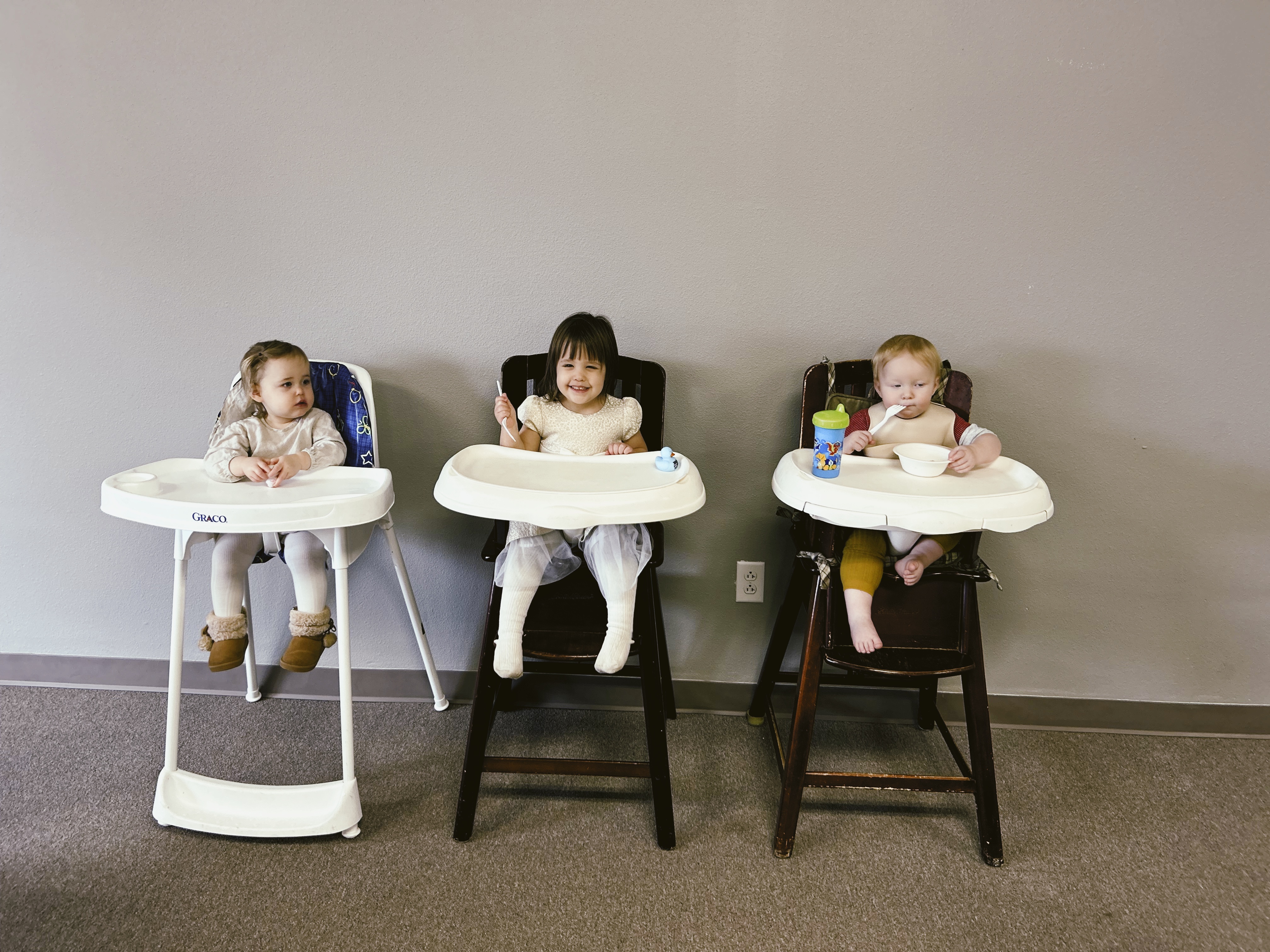 Three young children sit happily in high chairs at Valley Baptist Church in McMinnville, Oregon